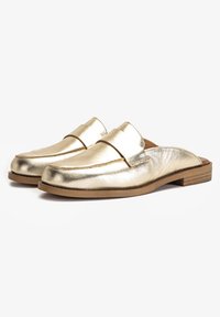 Guldmetallic läder slip-on skor med en platt trä-sula och minimalistisk design, med rundad tå och subtila sömdetaljer.