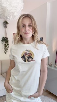 Trumpas baltas marškinėliai su grafiniu atvaizdu, vaizduojančiu dvi figūras raudona ir geltona, su "LEVI'S" logotipu apačioje. Minkšta medvilnės medžiaga.