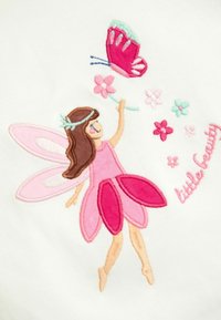 Geborduurd ontwerp met een fee met roze vleugels en een roze jurk, die een bloem en een vlinder vasthoudt. Tekst luidt "kleine schoonheid."