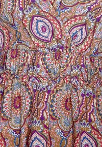 Multikleurige jurk met een paisleypatroon in tinten van roze, blauw en bruin. Elastische tailleband, lichte stof en ruches.