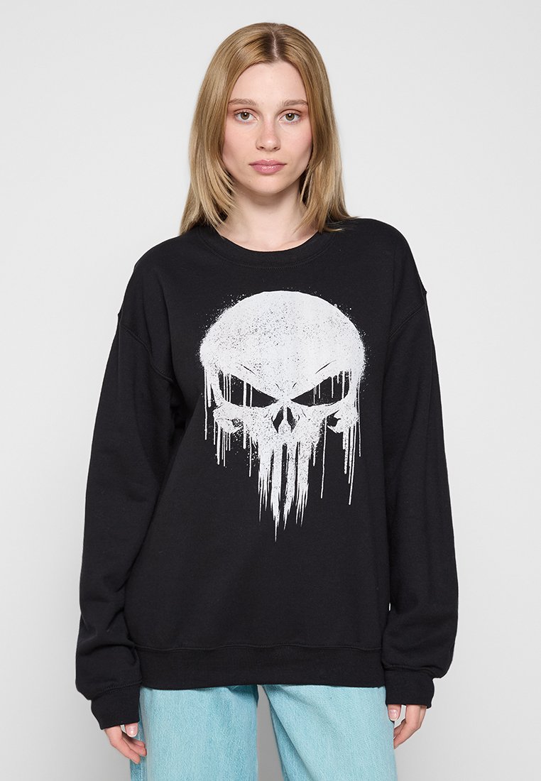 Svart sweatshirt med ett stort vitt dödskalletryck, rund hals och sänkt axel. Har ribbade manschetter och nederkant, tillverkad av mjukt material.