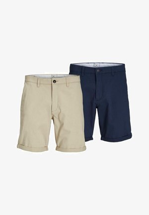 Granatowo-biała bawełniana koszulka w paski w połączeniu z beżowymi szortami. Białe skarpety do kostek i granatowe tenisówki dopełniają casualowy look.