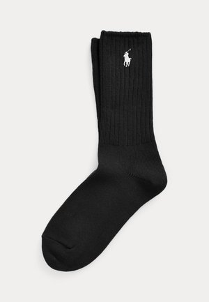 Paar schwarze, gerippte Knöchelsocken mit weißem Polo-Spieler-Logo, das nahe am oberen Bündchen gestickt ist.