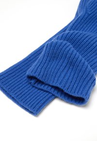 Suéter de lana azul de punto con textura acanalada, mangas largas y corte relajado, que destaca por su material suave y color uniforme.