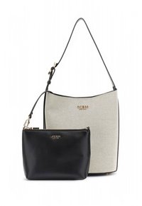 Kaks kotti: suur beež tekstuuriga ostukott musta sangaga ja kuldse logoga, kaaslasena väiksem elegantne must lukuga kott kuldse logoga.