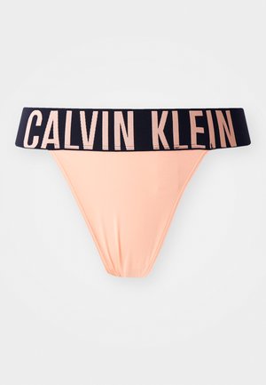 Perizoma da donna Calvin Klein in tessuto pesca con una larga fascia in navy che presenta la scritta del marchio in rosa chiaro.