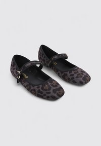 Zapatos Mary Jane de tela negra con un patrón de print de leopardo, punta redonda y una correa con detalle de hebilla dorada. Textura suave y suela plana.