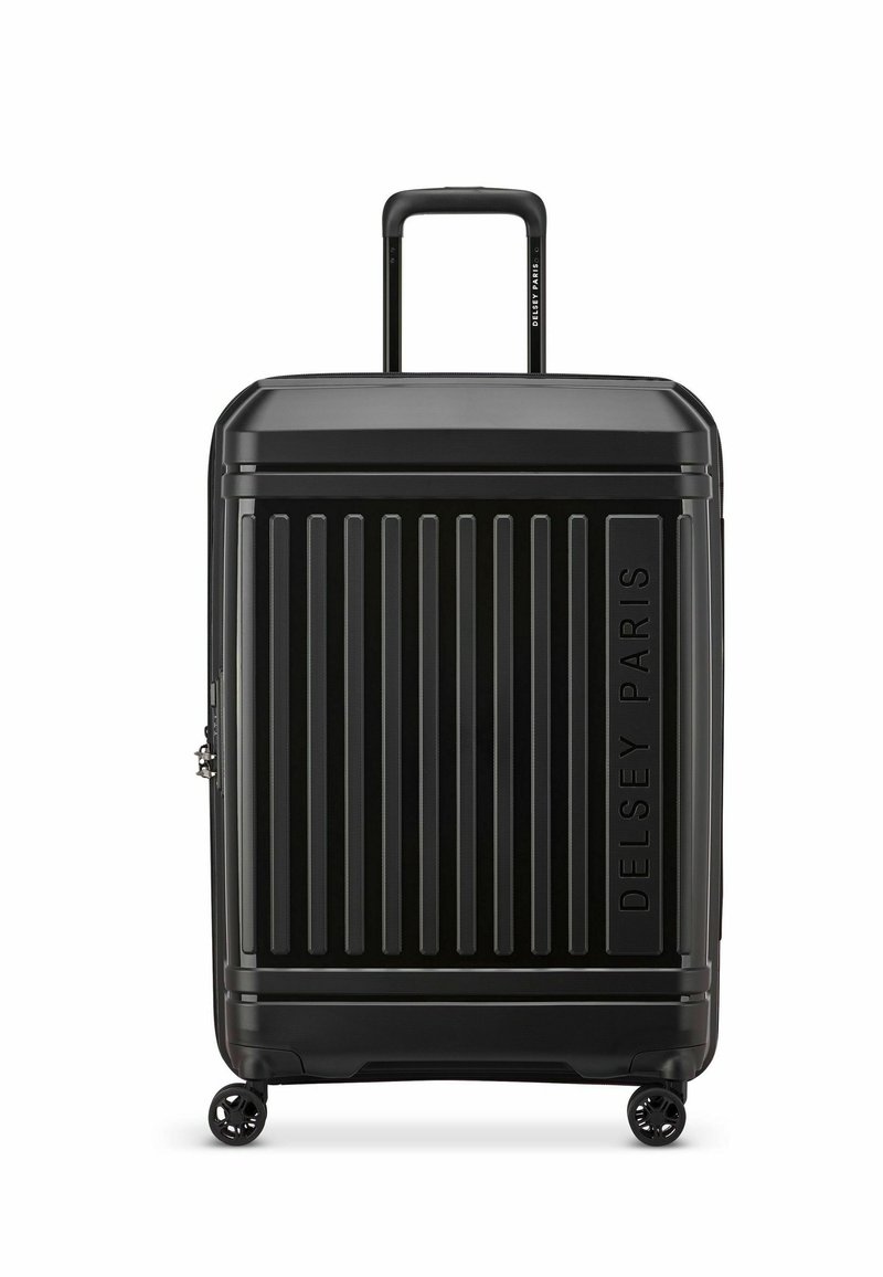 Maleta negra de plástico duro con surcos verticales, asa extensible y cuatro ruedas. Presenta el logotipo en relieve "Delsey Paris" en la parte delantera.