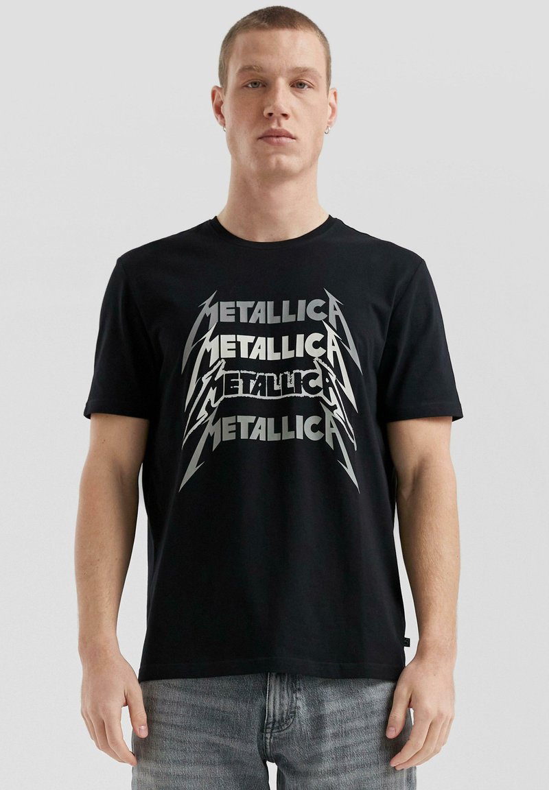 Schwarzes Baumwoll-T-Shirt mit einem großen, metallisch-silbernen "Metallica"-Grafik in fetter Schrift. Kurze Ärmel und klassische Passform.
