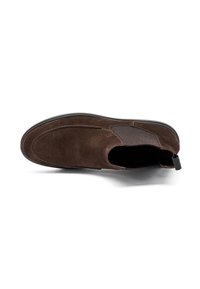 Zapato de ante marrón tipo slip-on con paneles laterales elásticos, puntera redonda y suela de goma plana. Cuenta con una tira en el talón para facilitar su uso.