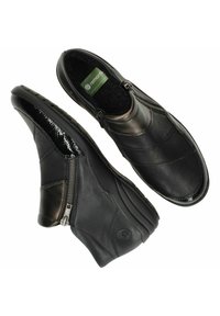 Stivali ankle in pelle nera con punta lucida, chiusura con zip laterale e pannelli testurizzati per un tocco di dettaglio in più. Interno morbido e imbottito.