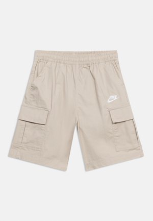 Világos bézs Nike cargo rövidnadrágok elasztikus derékpánttal, oldalzsebekkel és a jobb combon fehér Nike logóval.