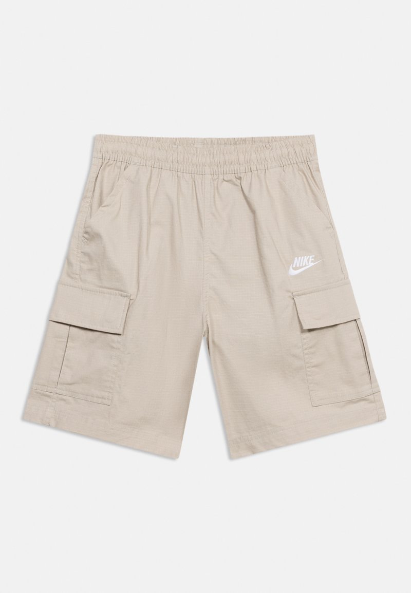 Ανοιχτό μπεζ cargo σορτς της Nike με ελαστική μέση, πλαϊνές τσέπες και λευκό λογότυπο Nike στο δεξί μηρό.