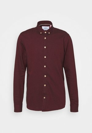 Cămașă burgundy cu mânecă lungă și guler cu nasturi, având nasturi din lemn și o textură netedă. Fără modele sau accente vizibile.