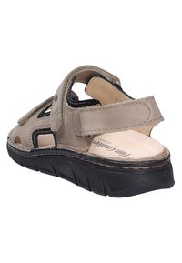 Sandalo beige in pelle con suola nera, punta e tallone aperti, cinturini regolabili con chiusura a strappo e soletta imbottita con etichetta "Finn Comfort".