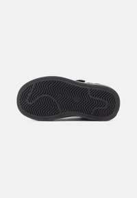Sole nera di scarpa con motivo di battistrada a zigzag e geometrico, con la marcatura della taglia "27/180" al centro su sfondo bianco.
