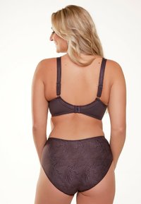 Donkerbruine beha met verstelbare bandjes en haaksluiting, gecombineerd met high-waisted slips die een subtiel zebra-patroon hebben.