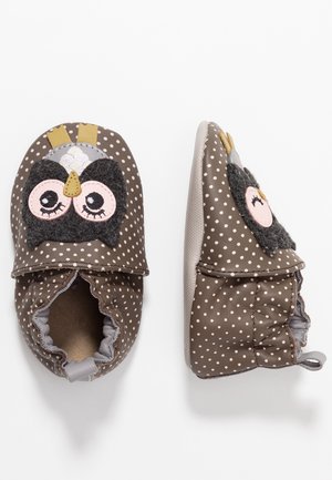 Brązowe dziecięce buty w jasnoróżowe kropki i z wizerunkiem sowy, jeden but widoczny z góry, drugi z boku.