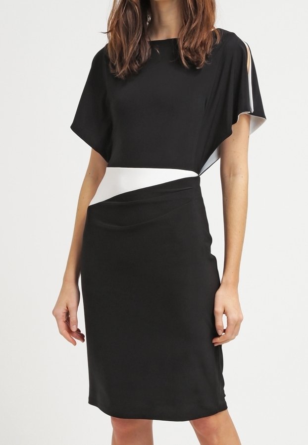 Svart klänning med en lös högermudd på kort ärm och en tajt kjol. Har ett vitt midjeband och en mjuk tygtextur.