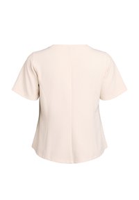 Krótki rękaw, jasnobeżowa bluzka z okrągłym dekoltem i gładką fakturą, charakteryzująca się prostym wzornictwem oraz subtelnymi detalami szwów z tyłu.