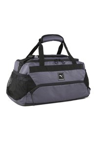 Bolso de deporte en tejido gris oscuro con detalles en negro, que cuenta con asas superiores, un compartimento principal con cremallera y un bolsillo lateral de malla para ventilación.