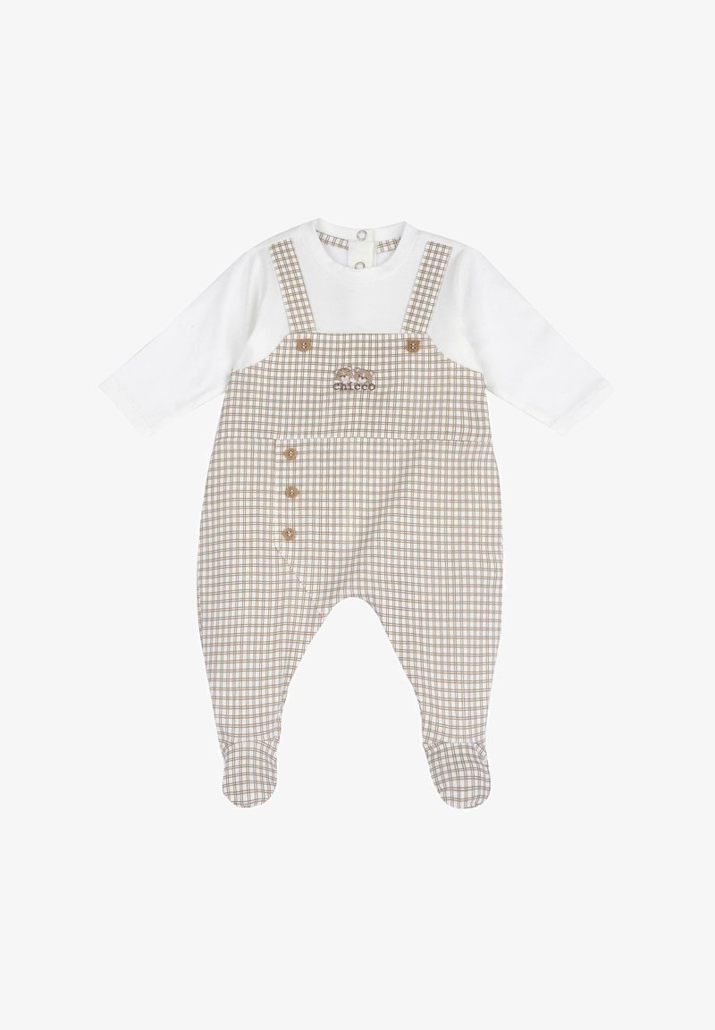 Salopette à carreaux avec un haut blanc à manches longues attaché. Présente un motif à carreaux marron et blanc, des boutons sur le côté, et un tissu doux.