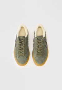 Adidași verzi din suede cu căptușeală din blană sintetică crema, vârf rotund și talpă din cauciuc caramel; prezintă accente cu logo negru și un design clasic cu șireturi.