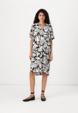 Kurzärmliges Kleid aus leichtem Material, mit einem schwarz-weißen Blattmuster, V-Ausschnitt und einem leicht abgerundeten Saum über dem Knie.