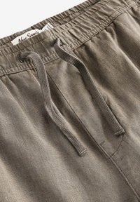 Grå linnedshorts med elastik i taljen, snørelukning og et struktureret, letvægtsstof. Inkluderer en sidelomme.