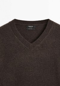 Brun kashmirtröja med V-ringning, med en mjuk textur och ribbad krage. Lappen läser "Massimo Dutti, 100 % kashmir."