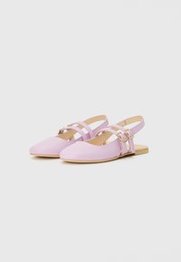 Vaaleanpunaiset slingback-kengät, joissa on litteä pohja, kahdella ristikkäin kulkevalla hihnalla ja kultaisilla soljilla, sekä sileä, kiiltävä pinta.