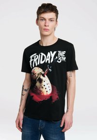 Black cotton t-shirt featuring a graphic with a hockey mask and knife, with red splatter effect. Bold "FRIDAY THE 13TH" text in white.