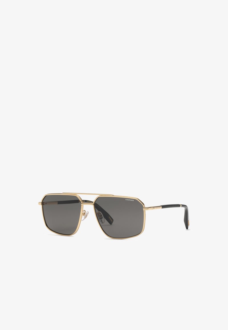 Lunettes de soleil rectangulaires à monture dorée avec verres gris foncé et branches noires, marquées Chopard dans le coin supérieur du verre droit.