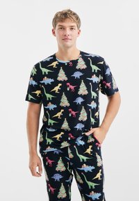 Heren pyjama set in marineblauwe stof met kleurrijke patronen van dinosaurussen en kerstbomen, korte mouwen en een relaxte pasvorm.