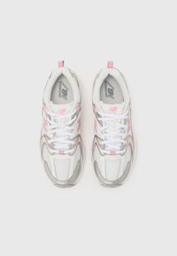 New Balance bėgimo batai su balta ir rožine tinkleliu, sidabrinėmis detalėmis ir baltos spalvos raišteliais. Yra paminkštinta apykaklė ir logotipo detalės.