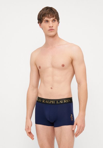 Námornícke boxerky s čiernym pásom, na ktorom je zlatými písmenami napísané "POLO RALPH LAUREN". Vyšívané logo na ľavej strane. Mäkký bavlnený materiál.