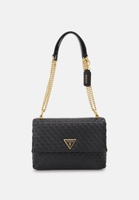 Sac à main tissé noir avec une poignée en cuir lisse et une chaîne dorée. Accentué d'un logo triangulaire Guess à l'avant.