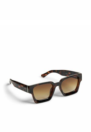 Rektangulære solbriller med skildpaddeprint, tykke stel og gradientbrune linser, der hviler på en hvid overflade.