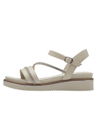 Sandalo beige con multiple cinghie incrociate e un accento luccicante. Presenta una suola a zeppa con fondo testurizzato per una migliore aderenza. Chiusura con fibbia.