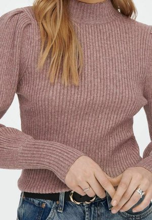 Geribbelde pullovertrui in licht mauve met een hoge halslijn en lange mouwen, voorzien van geplooide schouders, gecombineerd met donkere denim en een riem.