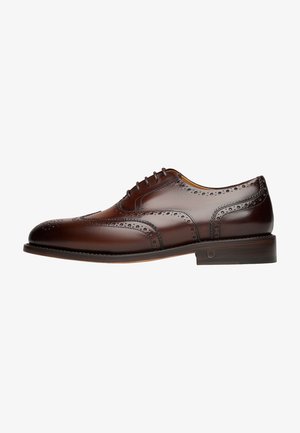 Scarpa da dress in pelle marrone con dettagli brogue, finitura liscia, punta rotonda, sei fori per i lacci e tacco impilato. Perforazioni sottili lungo i bordi.