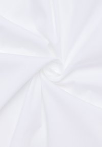 Tessuto bianco disposto a spirale, con una texture liscia e un colore uniforme senza pattern o accenti visibili.