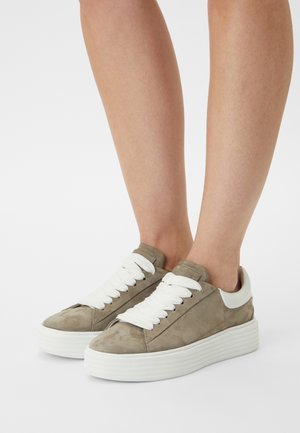 Baskets en suede grises avec une semelle et des lacets blancs, présentant une texture lisse, un bout arrondi et un design minimaliste.