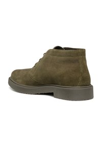 Stivaletti alla caviglia in suede verde oliva con punta rotonda, lacci a contrasto e suola in gomma con texture. Design minimalista con cuciture discrete.