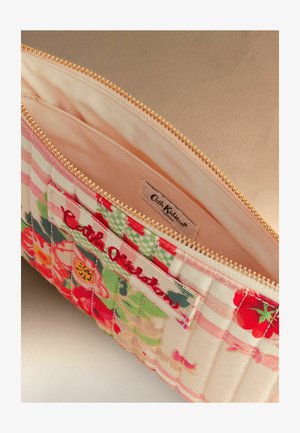 Lillemustriga kangast kotike roosa voodri, kuldse luku ja sees oleva Cath Kidstoni sildiga.