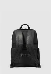 Sac à dos noir avec bretelles rembourrées, tissu texturé et détails lisses. Dispose d'une poignée supérieure et de sangles ajustables pour un ajustement parfait.