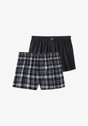 Zwei Paar Boxershorts: eine schwarze mit glatter Textur und elastischem Bund, die andere in einem schwarz-grauen Karomuster mit Knöpfen.