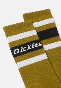 Pari siniset sukat, joissa on valkoisia ja mustia raitoja, ja mustalla raidalla on valkoisilla kirjaimilla merkin nimi "Dickies".