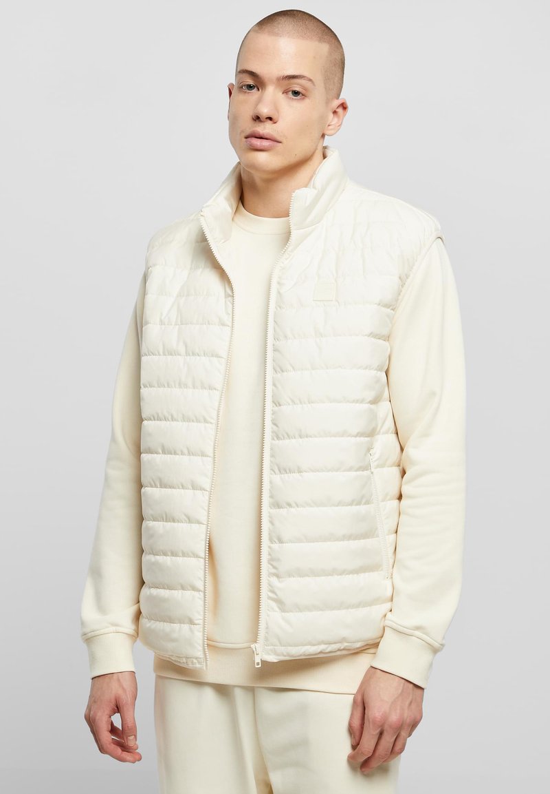 Kreemivärvi papagoiliiv, millel on värvitud muster, kõrge krae ja tõmblukuga sulgur. Sobitatud sama tooni ümara kaelusega dressipluusiga.