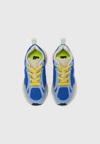 Μπλε αθλητικά παπούτσια από δίχτυ με κίτρινες κο ρδόνια, ανοιχτά μπλε στοιχεία και μπεζ σόλα. Διαθέτουν πράσινη επένδυση εσωτερικά και θηλιά στο πίσω μέρος για εύκολο φόρεμα.